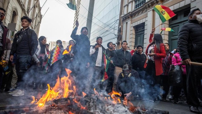 Mencekam! Warga Bolivia Bentrok dengan Tentara Melawan Kudeta People wave Bolivia's national flag as they yell at the military police during a coup attempt against the government of Bolivian President Luis Arce by military units led by General Juan Jose Zuniga, in La Paz, Bolivia June 26, 2024. REUTERS/Sara Aliaga
