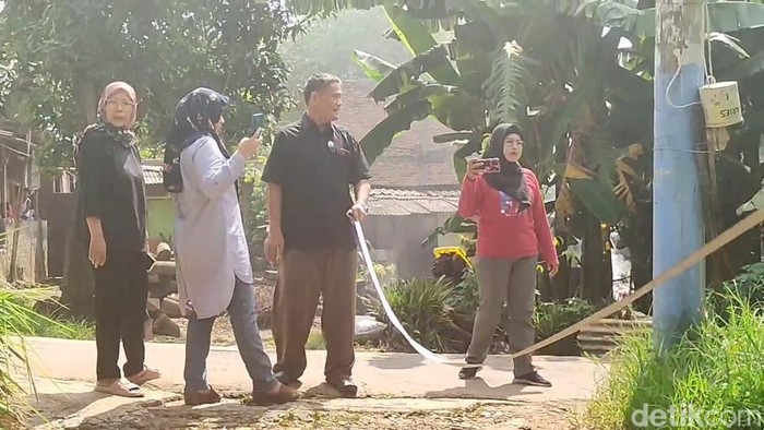 Ortu siswa ukur jarak dari rumah ke sekolah pakai meteran usai anaknya tak lolos PPDB jalur zonasi. (Devi/detikcom)