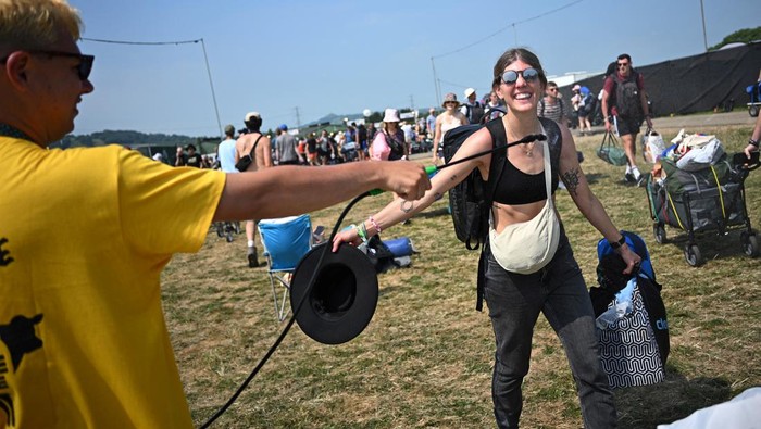 Revellers haul luggage as they arrive at Worthy Farm in Pilton, Somerset for the Glastonbury Festival, Britain, June 26, 2024. REUTERS/Dylan Martinez
