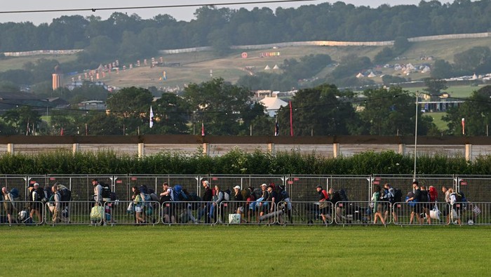 Revellers haul luggage as they arrive at Worthy Farm in Pilton, Somerset for the Glastonbury Festival, Britain, June 26, 2024. REUTERS/Dylan Martinez