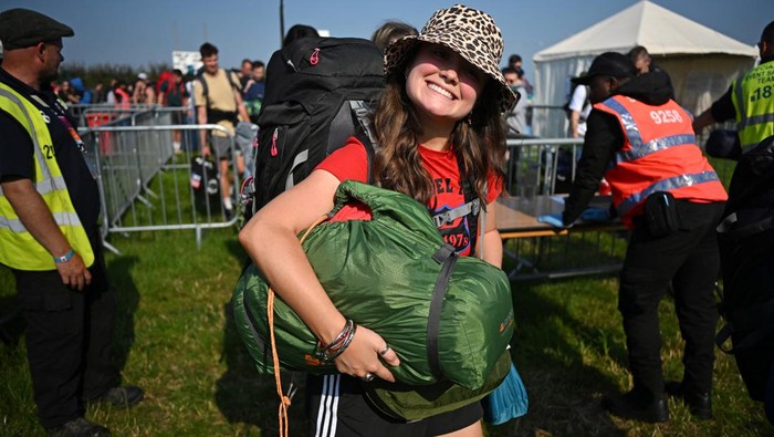 Revellers haul luggage as they arrive at Worthy Farm in Pilton, Somerset for the Glastonbury Festival, Britain, June 26, 2024. REUTERS/Dylan Martinez