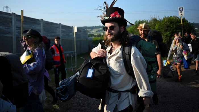 Revellers haul luggage as they arrive at Worthy Farm in Pilton, Somerset for the Glastonbury Festival, Britain, June 26, 2024. REUTERS/Dylan Martinez