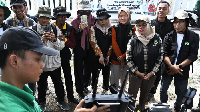 Petani mengamati drone yang digunakan untuk menyemprotkan pestisida di Sukamakmur, Desa Sukakarya, Kabupaten Bekasi, Jawa Barat, Kamis (27/6/2024). Dinas Pertanian setempat menggunakan teknologi drone untuk penyemprotan pestisida karena dinilai lebih efektif dan efisien bila dibandingkan cara konvensional karena hanya memakan waktu 10 menit untuk lahan satu hektare dengan tarif Rp250 ribu per hektarnya. ANTARA FOTO/ Fakhri Hermansyah/aww.
