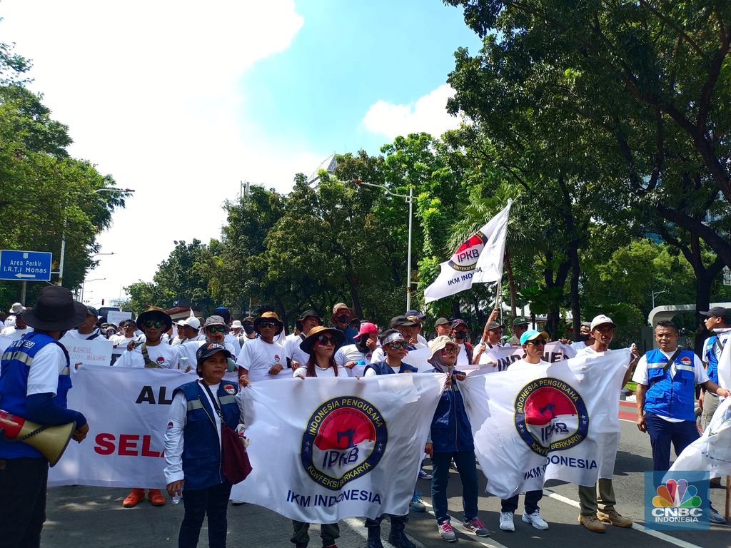 Ratusan buruh tekstil melakukan longmarch dari IRTI menuju Patung Kuda Jakarta, Kamis (27/6/2024). Massa yang tergabung dalam aliansi IKM & Pekerja Tekstil Indonesia menuntut tanggung jawab atas badai pemutusan hubungan kerja (PHK) di sejumlah industri tekstil dan produk tekstil (TPT) yang marak belakangan ini. (CNBC Indonesia/Martyasari Rizky)