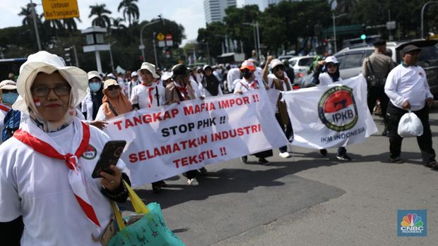 Ratusan buruh tekstil melakukan longmarch dari IRTI menuju Patung Kuda Jakarta, Kamis (27/6/2024). Massa yang tergabung dalam aliansi IKM & Pekerja Tekstil Indonesia menuntut tanggung jawab atas badai pemutusan hubungan kerja (PHK) di sejumlah industri tekstil dan produk tekstil (TPT) yang marak belakangan ini. (CNBC Indonesia/Tri Susilo)