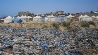 Sampah menumpuk di samping tenda darurat bagi warga Palestina yang mengungsi akibat serangan udara dan darat Israel di kamp pengungsi Nuseirat, Gaza, 20 Juni 2024.  