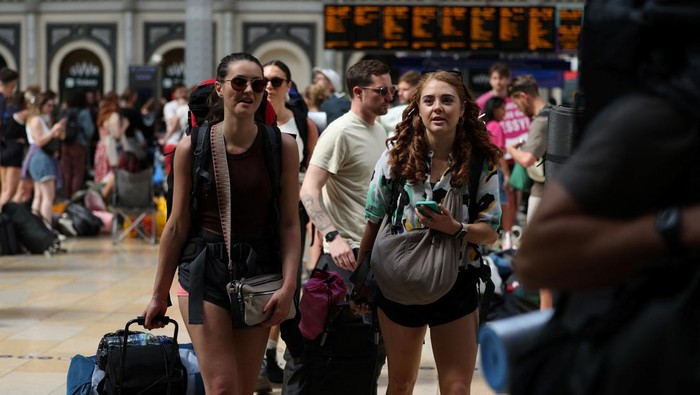 Stasiun Paddington London Dipenuhi Penggemar Musik Glastonbury Festival Revellers walk to board a train for the Glastonbury Festival, at Paddington Station in London, Britain, June 26, 2024. REUTERS/Isabel Infantes