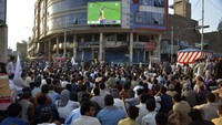 Penggemar kriket Afghanistan menyaksikan pertandingan semifinal Cricket World Cup T20 putra antara Afghanistan dan Afrika Selatan, di layar lebar di kota Jalalabad, timur Afghanistan, Kamis (27/6/2024).  