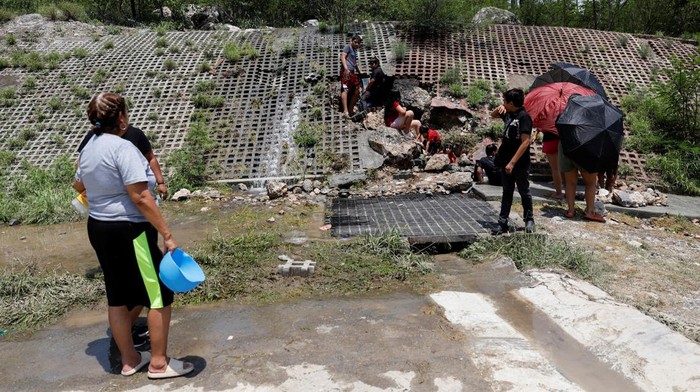 Warga Meksiko Mandi di Jalanan Imbas Pipa Air Minum Dirusak Badai People collect water from the runoff of the Topo Chico mountain, after drinking water pipes were damaged by tropical storm Alberto, in San Pedro Garza Garcia, Mexico June 26, 2024. REUTERS/Daniel Becerril