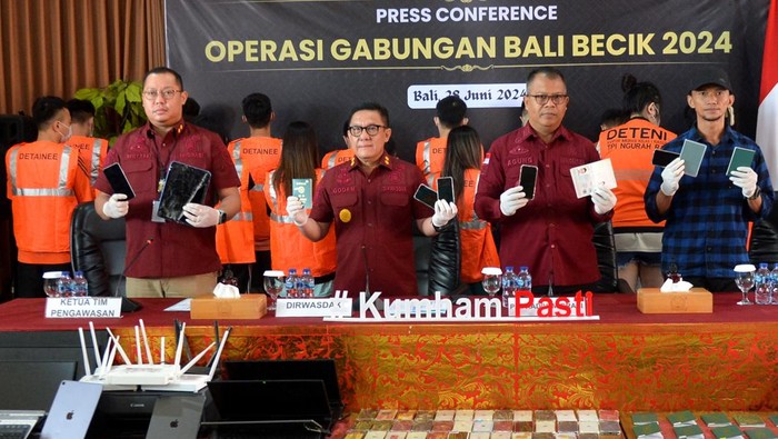 103 WN Taiwan Sindikat Scamming Ditangkap di Bali Petugas menunjukkan barang bukti sejumlah ponsel yang disita dari warga negara Taiwan yang ditangkap dalam operasi keimigrasian Bali Becik saat konferensi pers di Rumah Detensi Imigrasi Denpasar, Badung, Bali, Jumat (28/6/2024). Sebanyak 103 orang warga Taiwan yang ditangkap di sebuah vila di wilayah Tabanan, Bali pada Rabu (26/6) itu diduga melakukan kejahatan siber berupa scamming terhadap para korban yang berada di wilayah Malaysia dan akan segera dideportasi karena menyalahgunakan izin tinggal di Indonesia. ANTARA FOTO/Fikri Yusuf/tom.