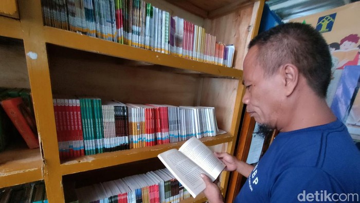 Abah Edi membaca buku di perpustakaan Lapas