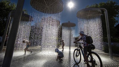 Bermain di Pancuran Air Taman Kota Lituania Saat Cuaca Menyengat
