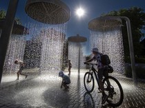 Bermain di Pancuran Air Taman Kota Lituania Saat Cuaca Menyengat