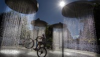 Air mancur di taman kota menjadi tempat warga untuk mendinginkan diri di tengah gelombang panas.  