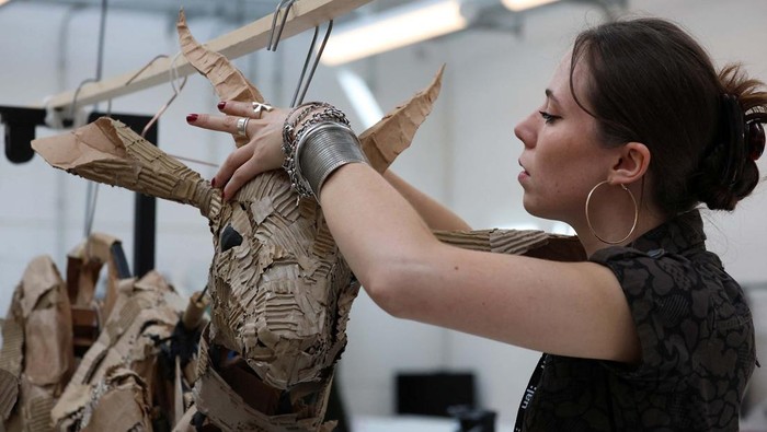 A puppeteer displays a life-size puppet of a wild animal at the launch of 