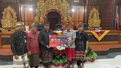 Direktur Utama Bank BPD Bali I Nyoman Sudharma saat menyerahkan secara simbolis KKI kepada Bupati Karangasem I Gede Dana di Wantilan kantor Bupati Karangasem, Kamis (27/6/2024). (I Wayan Selamat Juniasa)