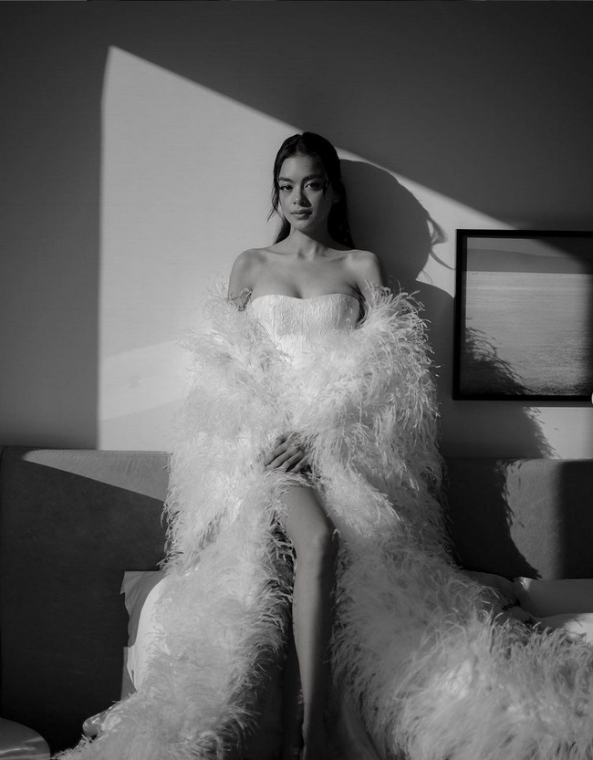 Bridal robe memungkinkan kamu leluasa bergerak dan nyaman saat menata rambut dan wajah, tanpa khawatir merusak gaun pengantin. Eva Celia, mengenakan bridal robe beraksen bulu karya Hian Tjen. Foto: Instagram