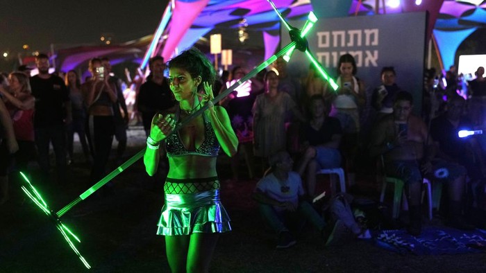 Israel Kembali Gelar Konser Musik yang Tahun Lalu Diserang Hamas Music fans enjoy the Nova Healing Concert in Tel Aviv, Israel, on Thursday, June 27, 2024. This was the first Tribe of Nova mass gathering since the Oct. 7, 2023 cross-border attack by Hamas that left hundreds at the Nova music festival dead or kidnapped to Gaza. (AP Photo/Ohad Zwigenberg)