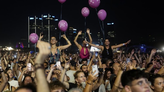 Israel Kembali Gelar Konser Musik yang Tahun Lalu Diserang Hamas Music fans enjoy the Nova Healing Concert in Tel Aviv, Israel, on Thursday, June 27, 2024. This was the first Tribe of Nova mass gathering since the Oct. 7, 2023 cross-border attack by Hamas that left hundreds at the Nova music festival dead or kidnapped to Gaza. (AP Photo/Ohad Zwigenberg)