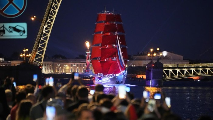 A brig with scarlet sails floats through drawbridges on the Neva River during a rehearsal for the Scarlet Sails festivities marking school graduation in St. Petersburg, Russia, Friday, June 28, 2024. (AP Photo/Dmitri Lovetsky)