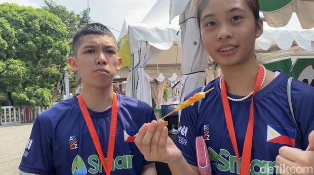 Pebulutangkis Filipina, Zeth Quiambao dan Fuentespina Christei Rei makan telur gulung di sela event Badminton Asia Junior Championships 2024 di GOR Among Rogo Jogja, Jumat (28/6/2024).