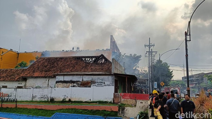 Petugas damkar berusaha memadamkan api yang membakar dua ruko tua di Jalan Jenderal Sudirman Purwokerto, Kabupaten Banyumas, Jumat (28/6/2024).