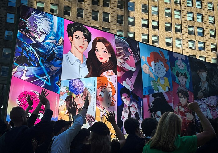 Saham Komik Online Webtoon Melonjak 14 Persen Saat Debut di Nasdaq Graphics for the Online comics platform Webtoon Entertainment are displayed in Times Square as the company holds an IPO at the Nasdaq MarketSite in New York City, U.S., June 27, 2024. REUTERS/Mike Segar