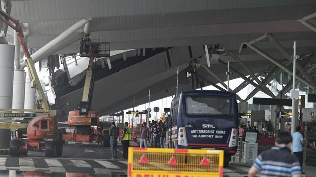 Seorang kru memeriksa kerusakan pada bagian kanopi terminal keberangkatan di Bandara Internasional Indira Gandhi New Delhi yang runtuh akibat hujan lebat sebelum musim hujan di New Delhi, India, Jumat, 28 Juni 2024. (AP Photo)