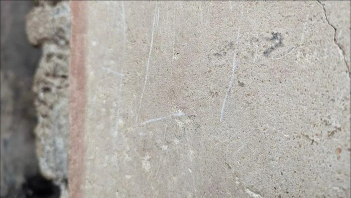Turis membuat coretan di situs Pompeii, Italia.