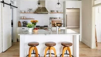 Plafon dan pencahayaan di atasnya yang terbuka menambah estetika industrial. Sepasang lampu kaca bergaya modern, dan tiga buah bangku dengan bantal kulit yang sudah usang memberi nuansa vintage. Foto: JOHN GRANEN via Better Homes & Gardens