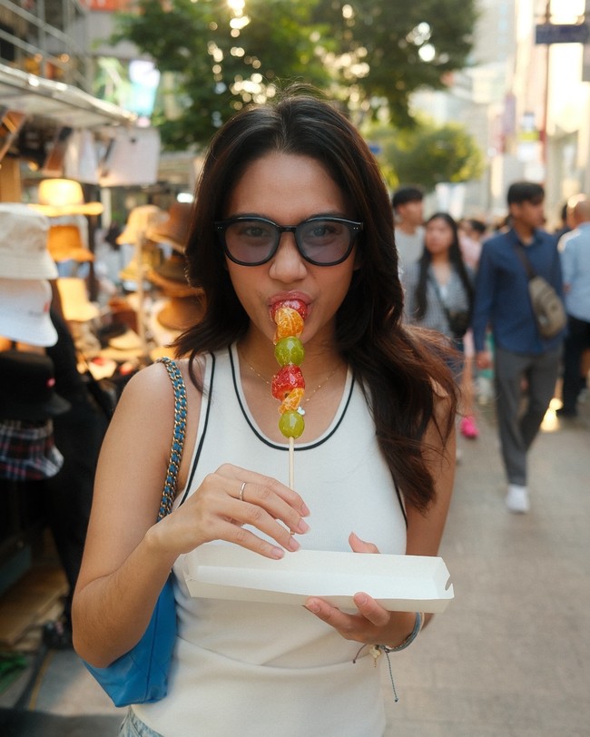 Begini gayanya saat menikmati tanghulu yang jadi viral di Korea. Foto: Instagram