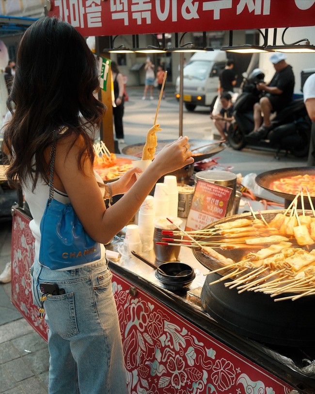 Dalam foto yang dibagikannya, Azizah tampak menikmati jajan pinggir jalan di Myeongdong. Foto: Instagram