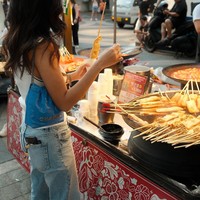 Dalam foto yang dibagikannya, Azizah tampak menikmati jajan pinggir jalan di Myeongdong. Foto: Instagram