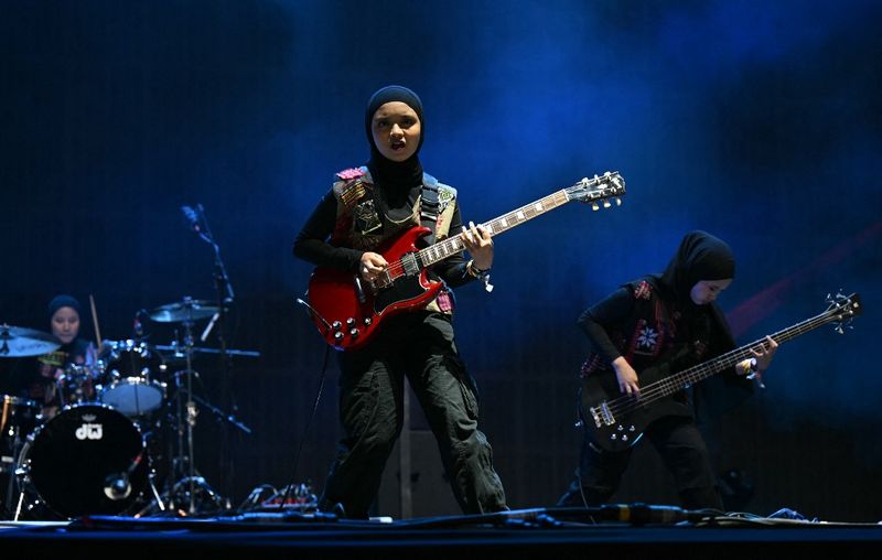 Indonesian rock band, Voice of Baceprot, comprised of Firda Marsya Kurnia (C), Widi Rahmawati (R) and drummer Euis Siti Aisyah perform on the Woodsies stage on the third day of the Glastonbury festival at Worthy Farm in the village of Pilton in Somerset, southwest England, on June 28, 2024. The festival takes place from June 26 to June 30. (Photo by Oli SCARFF / AFP)