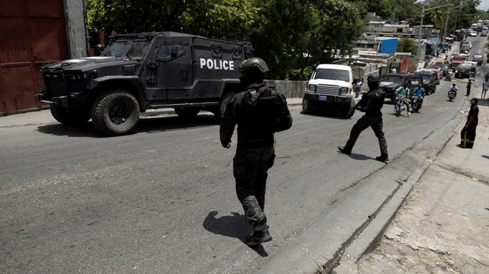 Potret Patroli Keamanan di Haiti Perangi Geng Bersenjata Kenyan Police guard the site where one of the armoured vehicles used by the Kenyan police and Haitian National police SWAT units to patrol broke down on a steep hill while patrolling through a neighborhood, after the arrival of the first contingent of Kenyan police as part of a peacekeeping mission, in Port-au-Prince, Haiti June 28, 2024. REUTERS/Ricardo Arduengo