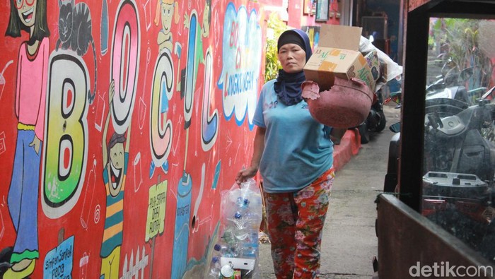 Seorang warga membawa tumpukan sampah untuk ditukar di Bank Sampah Kampung Cibunut, Kota Bandung.