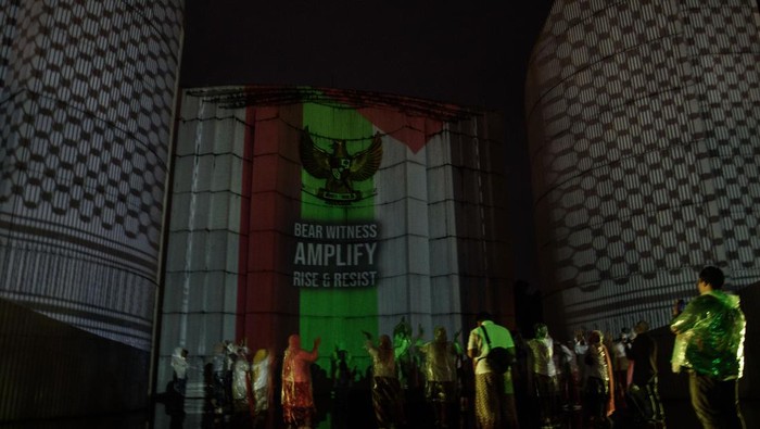 Aksi video mapping untuk Palestina Warga melakukan doa bersama saat aksi video mapping dukungan untuk Palestina yang divisualkan di Monumen Perjuangan Rakyat Jawa Barat, Bandung, Jawa Barat, Sabtu (29/6/2024). Aksi yang diinisiasi oleh Sembilan Matahari dan Bandung Creative City Forum tersebut merupakan seni intervensi di ruang publik untuk terus berkampanye dan meningkatkan kesadaran generasi muda dalam menolak kejahatan kemanusiaan serta penjajahan yang terjadi di Palestina. ANTARA FOTO/Novrian Arbi/rwa.