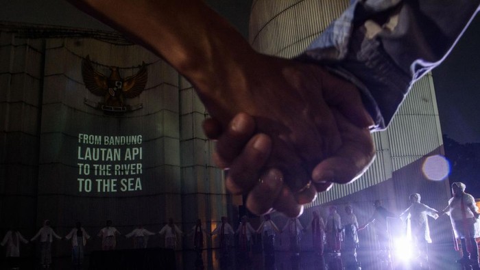 Warga melakukan doa bersama saat aksi video mapping dukungan untuk Palestina yang divisualkan di Monumen Perjuangan Rakyat Jawa Barat, Bandung, Jawa Barat, Sabtu (29/6/2024). Aksi yang diinisiasi oleh Sembilan Matahari dan Bandung Creative City Forum tersebut merupakan seni intervensi di ruang publik untuk terus berkampanye dan meningkatkan kesadaran generasi muda dalam menolak kejahatan kemanusiaan serta penjajahan yang terjadi di Palestina. ANTARA FOTO/Novrian Arbi/rwa.