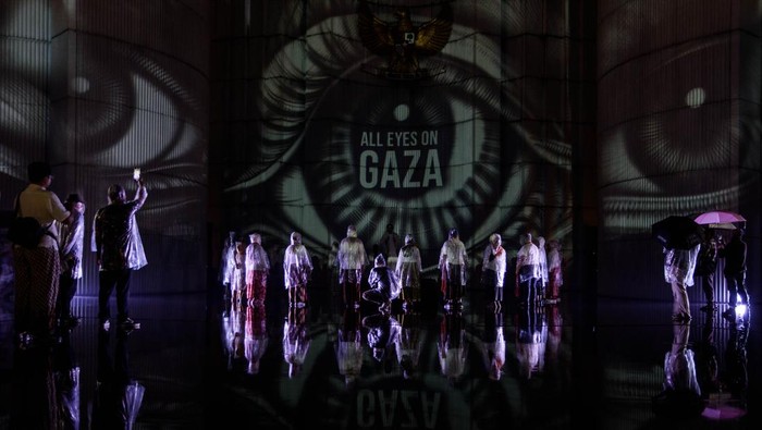 Warga melakukan doa bersama saat aksi video mapping dukungan untuk Palestina yang divisualkan di Monumen Perjuangan Rakyat Jawa Barat, Bandung, Jawa Barat, Sabtu (29/6/2024). Aksi yang diinisiasi oleh Sembilan Matahari dan Bandung Creative City Forum tersebut merupakan seni intervensi di ruang publik untuk terus berkampanye dan meningkatkan kesadaran generasi muda dalam menolak kejahatan kemanusiaan serta penjajahan yang terjadi di Palestina. ANTARA FOTO/Novrian Arbi/rwa.