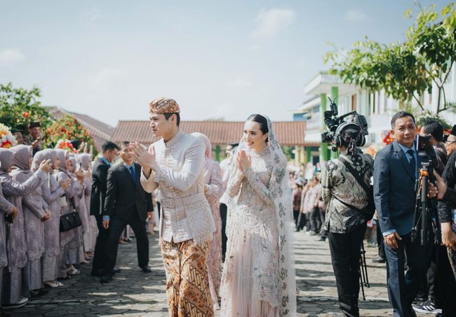 Beby Tsabina tampil cantik dengan dress berwarna nude yang dipenuhi payet. Penampilannya semakin anggun dan menawan dengan kerudung berbahan kain tulle yang dipercantik dengaan payet berbentuk bunga warna-warni pada bagian list kain. Foto: Instagram/@bebytsabina