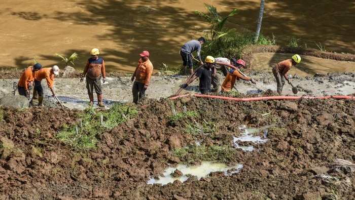 Sejumlah petugas BPBD Kabupaten Tasikmalaya dan relawan membersihkan material tanah longsor yang menimbun jalan penghubung antarkecamatan di Desa Nangtang, Kabupaten Tasikmalaya, Jawa Barat, Minggu (30/6/2024). BPBD Kabupaten Tasikmalaya mencatat sebanyak 17 titik di tujuh kecamatan Kabupaten Tasikmalaya mengalami bencana alam yakni longsor dan banjir. ANTARA FOTO/Adeng Bustomi/aww.
