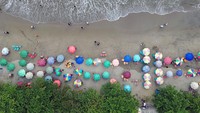 Foto udara sejumlah pengunjung memadati kawasan Pantai Padang, Sumatera Barat, Minggu (30/6/2024).