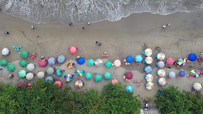 Foto udara sejumlah pengunjung memadati kawasan Pantai Padang, Sumatera Barat, Minggu (30/6/2024). Destinasi wisata pantai Padang menjadi pilihan bagi warga dan pengunjung menikmati masa libur panjang sekolah, karena akses utama ke Bukittinggi dan sekitarnya belum bisa dilewati sebab masih dalam perbaikan pascabanjir bandang bulan lalu. ANTARA FOTO/Iggoy el Fitra/aww.