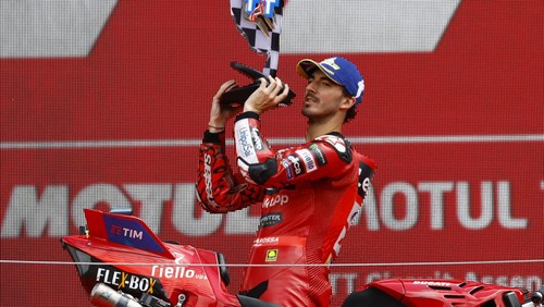 MotoGP - TT Assen Grand Prix - TT Circuit Assen, Assen, Netherlands - June 30, 2024 Ducati Lenovo Teams Francesco Bagnaia celebrates on the podium with a trophy after winning the race REUTERS/Piroschka Van De Wouw