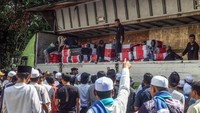 Jemaah haji antre mengambil koper di truk saat tiba di Cibinong , Kabupaten Bogor, Jawa Barat, Minggu (30/6/2024).