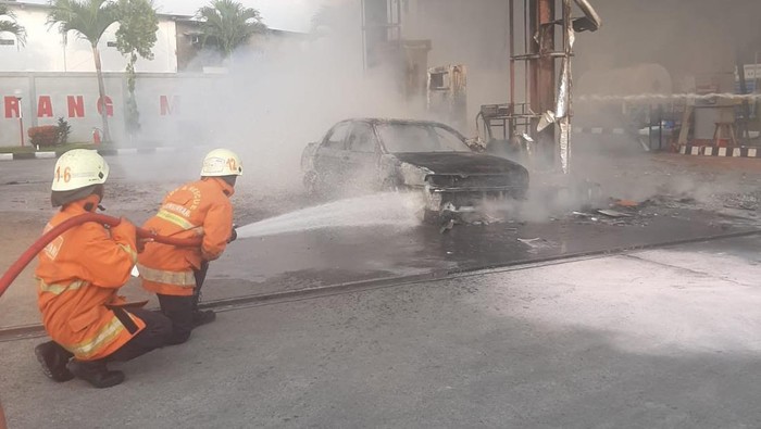 Petugas memadamkan mobil yang terbakar di SPBU Matesih, Karanganyar.