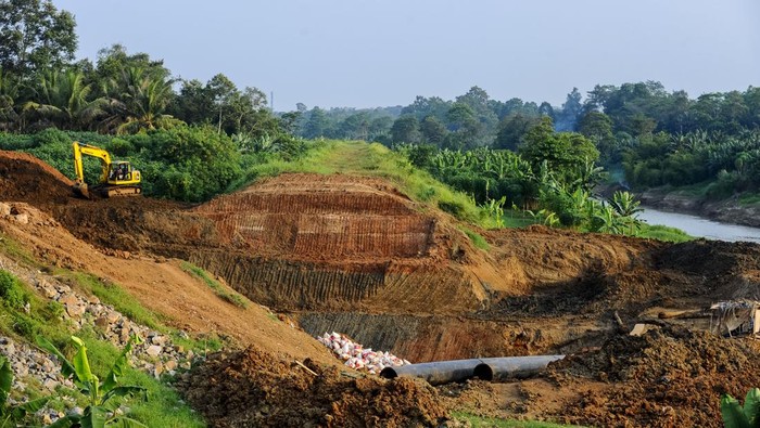 Pekerja menyelesaikan pembangunan tanggul dinding sungai Ciujung di Pamarayan, Kabupaten Serang, Banten, Minggu (30/6/2024). Progres pembangunan tanggul sungai Ciujung sepanjang 10,85 kilometer yang difungsikan untuk mengantisipasi terjadinya banjir tahunan di daerah tersebut telah mencapai 80 persen. ANTARA FOTO/Muhammad Bagus Khoirunas/aww.