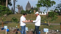 Presiden Direktur AXA Mandiri Handojo G. Kusuma (kiri) menyerahkan bibit pohon pewarna alami ke General Manager Taman Wisata Candi (TWC) Ratno Timur (kanan) dalam acara bertajuk Tanam Warna, Tanam Karsa, Tanam Harapan di komplek Candi Prambanan, Sleman, D.I Yogyakarta.