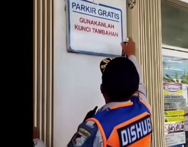 Tangkapan layar petugas Dishub Lombok Barat, NTB hapus papan bertuliskan 'Parkir Gratis' di Indomaret, Desa Terong Tawah, Kecamatan Labuapi. Foto: istimewa.