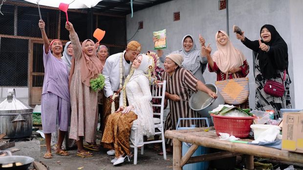 Foto pasangan Andy dan Yunda yang mengabadikan momen bersama ibu-ibu yang bertugas di dapur Foto pasangan Andy dan Yunda yang mengabadikan momen bersama ibu-ibu yang bertugas di dapur dan berjasa di hari pernikahannya. Unggahan tersebut langsung viral di media sosial